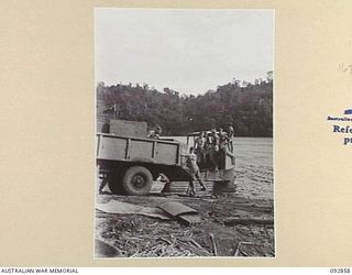 NANTAMBU, NEW BRITAIN. 1945-06. MEMBERS OF 37/52 INFANTRY BATTALION LOADING WATER TANKS ONTO A CAPTURED JAPANESE BARGE WHICH WILL DELIVER THEM TO WATU POINT. IDENTIFIED PERSONNEL ARE:- CORPORAL ..