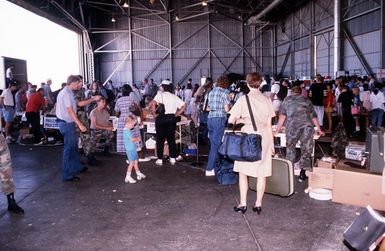 Hundreds of military and civilian personnel from the Philippine Islands wait in lines during evacuation processing. The evacuation is the result of the June 10 eruption of Mount Pinatubo, which deposited more than four inches of volcanic ash on the Islands. More than 20,000 evacuees have been removed from the area as a part of the U.S. military's Operation Fiery Vigil