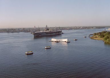 Crew members man the rails of the aircraft carrier USS KITTY HAWK (CV 63) as the ship passes the USS ARIZONA Memorial