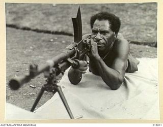 Papua, New Guinea. 1943-06. A native soldier with a Bren gun on the range at a Papuan Infantry Unit camp. This soldier later used a Bren gun to attack barges being operated by Japanese troops ..