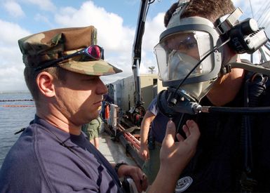 US Navy divers assigned to Mobile Diving and Salvage Unit One (MDSU-1) make final pre-dive checks aboard the Crowley 450-10 barge during recovery operations for the Japanese fishing vessel Ehime Maru off the coast of Hawaii