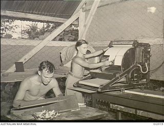 TOROKINA, BOUGAINVILLE ISLAND, SOLOMON ISLANDS. 1945-07-23. LEADING AIRCRAFTMAN (LAC) STANFORD DRYING PRINTS WITH LAC NICK LILWALL OF GYMPIE, QLD, TRIMMING THE FINISHED PHOTOGRAPHS AT THE RAAF ..