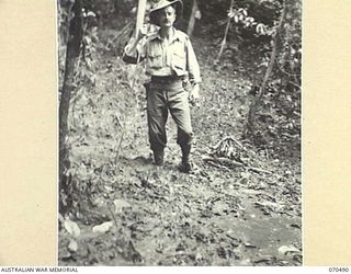 CAM'S SADDLE, FINISTERRE RANGE, NEW GUINEA, 1944-02-16. MR. JOHN SCARLETT, A WAR CORRESPONDENT OF THE "SYDNEY MORNING HERALD" PLOUGHING THROUGH MUD ON CAM'S SADDLE BETWEEN CRATER HILL AND ..