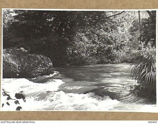 17 MILE, LALOKI RIVER, NEW GUINEA. 1943-11-22. THE LALOKI RIVER WHICH SUPPLIES THE WATER FOR THE CORDIAL FACTORY ESTABLISHED AND OPERATED BY THE AUSTRALIAN DEFENCE CANTEEN SERVICES, ATTACHED TO ..