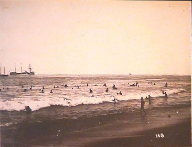 Warships and people in the surf