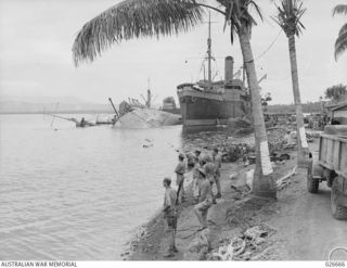 MILNE BAY, PAPUA. 1942-09. THE STEAMER "ANSHUN" LYING ON HER SIDE IN MILNE BAY, WHERE SHE WAS SHELLED AND SUNK BY A JAPANESE CRUISER. THE "ANSHUN" WAS LATER SALVAGED AND TOWED TO SYDNEY, A DISTANCE ..