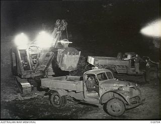 NADZAB, NEW GUINEA. C. 1944-02. WORKING IN SHIFTS, BY DAY AND BY NIGHT, RAAF MOBILE WORKS UNITS ARE BUILDING AIRSTRIPS IN RECORD TIME IN NG. BY THE LIGHT OF FLOODLIGHTS, THESE MEN OF NO. 62 MOBILE ..