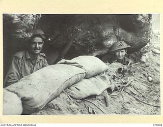 TSIMBA AREA, BOUGAINVILLE ISLAND. 1945-02-07/06. QX59609 PRIVATE E. HASTIE (1) AND QX53099 PRIVATE S. MISCHLEWSKI (2), COOKS OF THE 31/51ST INFANTRY BATTALION, TAKING COVER IN THEIR SLIT TRENCH ..