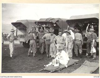 LAE, NEW GUINEA. 1944-08-18. PATIENTS OF THE 2/7TH GENERAL HOSPITAL BEING REMOVED FROM AMBULANCES AT THE WHARF FOR LOADING ABOARD THE 2/1ST HOSPITAL SHIP, "MANUNDA"