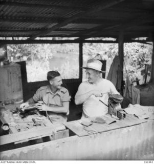 SOGERI VALLEY, NEW GUINEA. 1943-06-27. BOOT REPAIR SECTION OF THE NEW GUINEA FORCE SCHOOL OF SIGNALS. ON THE LEFT IS QX28119 SIGNALMAN R. J. APPLETON, UNIT BOOT REPAIRER. ON THE RIGHT IS VX31799 ..