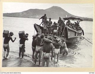 BLANCHE BAY, RABAUL, NEW BRITAIN. 1945-10-03. JAPANESE TROOPS LOADING SHELLS ON BARGES. THEY WILL BE DUMPED AT SEA UNDER 28 INFANTRY BATTALION SUPERVISION