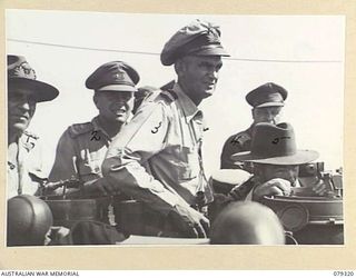 BUT AREA, NEW GUINEA. 1945-02-26. LIEUTENANT W.J. DOVERS RAN, SKIPPER OF HMAS SWAN TAKING A SIGHT OVER THE PELORUS FROM THE BRIDGE DURING A RAN BOMBARDMENT OF THE JAPANESE POSITIONS IN THE BUT- ..