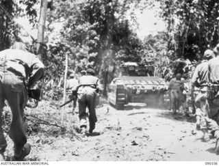 BOUGAINVILLE. 1945-04-05. A MATILDA TANK ADVANCING ALONG BUIN ROAD, SUPPORTED BY TROOPS OF 61 INFANTRY BATTALION IN ORDER TO CLEAR THE ROAD BETWEEN B ECHELON, 25 INFANTRY BATTALION HEADQUARTERS AND ..