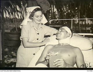 MADANG, NEW GUINEA. C. 1944-10. SISTER A. M. RODDA ATTENDING A PATIENT AT A RAAF MEDICAL RECEIVING STATION AT A FORWARD BASE IN NEW GUINEA