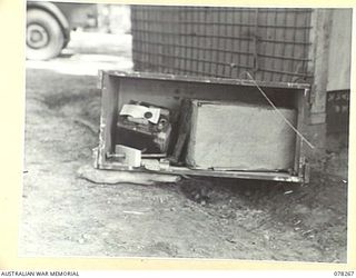 TOROKINA, BOUGAINVILLE ISLAND, 1945-01-05. AN EXAMPLE OF BAD PACKING IS SEEN FROM THIS SMASHED BATTERY AND RADIO WHICH ARRIVED AT THE ARMY AMENITIES SERVICE, 3RD DIVISION
