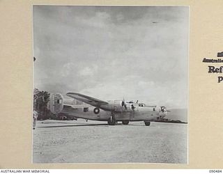 JACQUINOT BAY, NEW BRITAIN. 1945-04-09. THE FIRST BIG BOMBER, A RAAF LIBERATOR, TO LAND ON THE AIRSTRIP. THIS AIRCRAFT, IS CARRYING SENATOR J.M. FRASER, ACTING MINISTER FOR THE ARMY, AND OFFICIAL ..