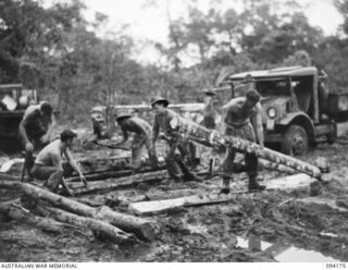 BOUGAINVILLE. 1945-07-19. ENGINEERS OF 23 FIELD COMPANY, ROYAL AUSTRALIAN ENGINEERS, LAYING CORDUROY ON THE BUIN ROAD EAST OF THE OGORATA RIVER TO ASSIST IN GETTING A 3-TONNER VEHICLE OUT OF MUD