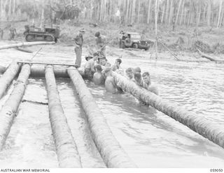 BUMI RIVER, NEW GUINEA. 1943-10-19. ENGINEERS OF THE 2/3RD AUSTRALIAN FIELD COMPANY, ROYAL AUSTRALIAN ENGINEERS CONSTRUCTING A NEW BRIDGE OVER THE RIVER TO REPLACE THE ONE WHICH WAS WASHED AWAY BY ..