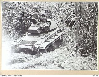 TOROKINA AREA, BOUGAINVILLE, 1945-08-14. AN M24 LIGHT TANK BELLIED IN THE MUD OF A CREEK DURING AN ATTEMPT TO CROSS IN TESTS CONDUCTED BY THE BRITISH WAR OFFICE TRIALS TEAM (TANKS)