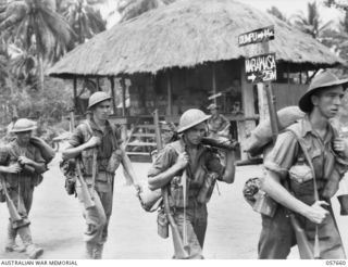 KAIAPIT, NEW GUINEA, 1943-09-27. TROOPS OF THE 2/31ST AUSTRALIAN INFANTRY BATTALION, 25TH AUSTRALIAN INFANTRY BRIGADE PASSING THROUGH KAIAPIT VILLAGE. SHOWN ARE, LEFT TO RIGHT:- QX16956 PRIVATE C. ..