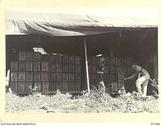 LAE, NEW GUINEA. 1944-03-30. TX11784 LIEUTENANT A. R. GRAY (LEFT), WITH LIEUTENANT LOCKE (RIGHT) AT A FIELD STACK OF 3 INCH MORTAR AMMUNITION IN THE BEACH TRANSIT DUMP, 103RD FIELD AMMUNITION DEPOT