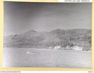 PORT MORESBY - DISTANT VIEW OF ROAD AROUND FORESHORES, WITH SIR HUBERT MURRAY'S FUNERAL CORTEGE PASSING AROUND CLIFF FACE TO BURIAL PLACE, HAMUABADA. (NEGATIVE BY N. TRACY)