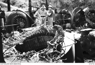 WAU, NEW GUINEA. 1944-04-25. THE HONOURABLE E.J. WARD, MINISTER FOR EXTERNAL TERRITORIES IN THE AUSTRALIAN GOVERNMENT (1), WITH MEMBERS OF HIS OFFICIAL PARTY INSPECTING THE WREAKAGE OF THE NO.1 ..