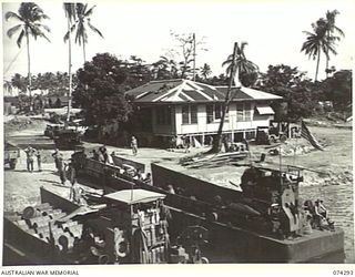 MADANG, NEW GUINEA. 1944-06-27. TROOPS OF THE 7TH DOCKS OPERATING COMPANY, UNLOADING SUPPLIES FROM AMERICAN BARGES