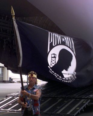 A Vietnam Veteran lets the MIA/POW flag wave beside the rear entrance ramp to a US Air Force C-17 Globemaster III that brought the remains of his American comrades home. The reparation ceremony was held on August 29th, 2000 at Hickam Air Force Base, Hawaii
