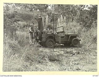 PIONEER CROSSING, PORT MORESBY AREA, PAPUA, 1944-03-25. VX113860 CORPORAL F.J. REEVES (1), WITH VX68221 PRIVATE J. FORD (2), THE DESIGNER OF THE MOBILE SHOWERS AND HEATING UNIT PICTURED AT THE ..