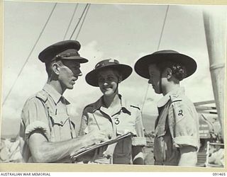 LAE, NEW GUINEA, 1945-05-07. LIEUTENANT F. BROWN, SHIP'S ADJUTANT, MV DUNTROON (1), GIVING LAST MINUTE DISEMBARKATION INSTRUCTIONS TO CAPTAIN L.D. CRANE (2), AND WARRANT OFFICER R.M. LAIRD (3). A ..