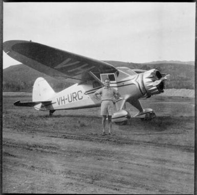 E.W.P. Chinnery standing beside a mono-plane, VH-URC, New Guinea, ca. 1936 / Sarah Chinnery