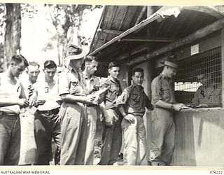 LAE, NEW GUINEA. 1944-09-28. MEMBERS OF THE 22ND WORKS COMPANY, ROYAL AUSTRALIAN ENGINEERS, RECEIVING MAIL AT THE UNIT POST OFFICE. IDENTIFIED PERSONNEL ARE:- V503051 PRIVATE W.M. EDWARDS (1); ..