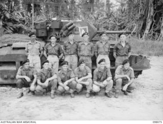 Group portrait of personnel of No. 7 Troop, B Squadron, 2/4th Armoured Regiment. Left to right, back row: TX8187 Sergeant C C Midson of Hobart, Tas; VX125537 Trooper (Tpr) K D Barrett of Fairfield, ..