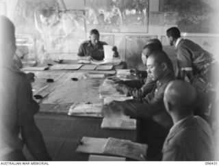 CAPE WOM, NEW GUINEA, 1945-09-13. SCENE DURING CONFERENCE BETWEEN STAFF OFFICERS OF 6 DIVISION, HEADED BY LIEUTENANT-COLONEL J. BISHOP GENERAL STAFF OFFICER I, AND STAFF OFFICERS OF 18 JAPANESE ..