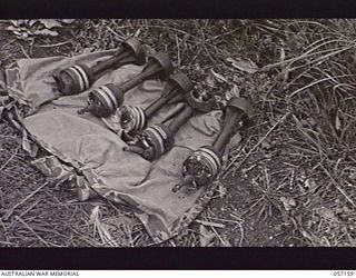 SOGERI VALLEY, NEW GUINEA. 1943-09-24. CLOSE UP OF THE BOMBS USED IN THE PROJECTOR INFANTRY TANK ATTACK MARK 1 WHICH DID NOT EXPLODE IN THE SHOOT AGAINST THE TEST PILLBOX. THESE BOMBS WILL BE ..