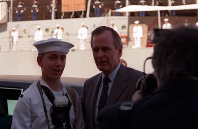 President George Bush poses for a photograph with a sailor during an observance commemorating the 50th anniversary of the Japanese attack on Pearl Harbor