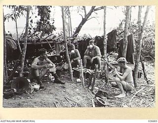 MILNE BAY, PAPUA. 1942-10. TROOPS OF THE 61ST AUSTRALIAN INFANTRY BATTALION 7TH BRIGADE A.M.F., JUNGLE COUNTRY ALONG THE SHORES OF MILNE BAY, STOP FOR A MEAL IN A CLEARING