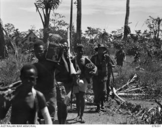 YAKAMUL, NEW GUINEA. 1945-01-09. MEMBERS OF THE 2/2ND INFANTRY BATTALION AND "JOCK FORCE" AND THEIR NATIVE CARRIERS LEAVING THEIR BASE CAMP AT THE START OF A 40 DAY PATROL THROUGH ENEMY OCCUPIED ..