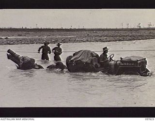 UMI RIVER, NEW GUINEA. 1943-09-29. A JEEP HAULING A 25 POUNDER GUN OF THE 21ST AUSTRALIAN INFANTRY BRIGADE ACROSS THE RIVER