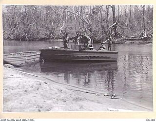 WEWAK AREA, NEW GUINEA. 1945-07-18. MEMBERS OF 2/22 FIELD PARK COMPANY, ROYAL AUSTRALIAN ENGINEERS, AND A PARTY OF AUSTRALIAN NEW GUINEA ADMINISTRATIVE UNIT NATIVES DISEMBARKING FROM A MOTOR LAUNCH ..
