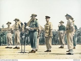 An Australian soldier reading an address to the Japanese surrender party (out of sight), including Lieutenant General Hatazo Adachi, during the official surrender ceremony marking the defeat of the ..