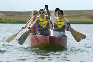 Aurora, CO July 19, 2005 Emily Matner (left), Shawn Martinet and Lendau De Leguna and other members of Team Imua Polynesia practice for next week's dragon boat races at Aurora Resevoir. Rick Giase/Special to the News