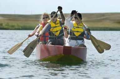 Aurora, CO July 19, 2005 Emily Matner (left), Shawn Martinet and Lendau De Leguna and other members of Team Imua Polynesia practice for next week's dragon boat races at Aurora Resevoir. Rick Giase/Special to the News