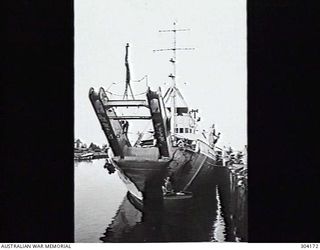 MANUS ISLAND, ADMIRALTY ISLANDS. 1949-09. BOW VIEW OF A BOOM DEFENCE VESSEL ALONGSIDE UNDERGOING ROUTINE MAINTENANCE. (NAVAL HISTORICAL COLLECTION)