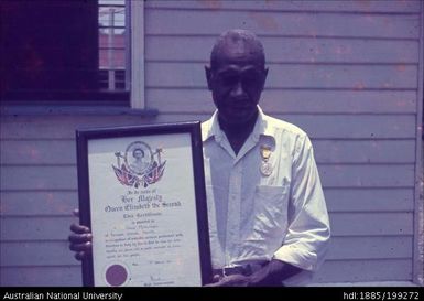 Chief Molirani holding certificate awarded for 26 years of service