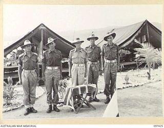 WEWAK POINT, NEW GUINEA. 1945-10-02. LIEUTENANT COLONEL R.R. GORDON, COMMANDING OFFICER 2/3 MACHINE-GUN BATTALION (3), AT THE SALUTING BASE WITH SERGEANT E. HAYLETT (2) AND CORPORAL G.A. LAMBERT ..