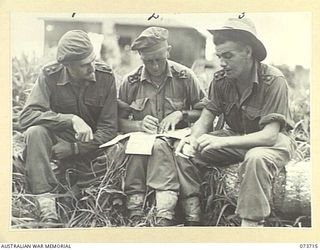 SARANG, NEW GUINEA. 1944-06-02. THREE OFFICERS OF C COMPANY, 37/52ND INFANTRY BATTALION IN DISCUSSION DURING THE PREPARATIONS FOR THE BEACH LANDING KARKAR ISLAND. IDENTIFIED PERSONNEL ARE:- VX50359 ..