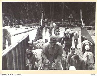PIEDU ISLAND, BOUGAINVILLE AREA. 1945-09-29. JAPANESE TROOPS FROM THE BUIN AREA UNLOADING GEAR FROM AN AUSTRALIAN LANDING BARGE AT A CONCENTRATION AREA ON PIEDU ISLAND. THE SURRENDER PARTY FROM ..