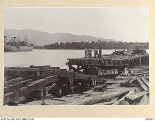 MILFORD HAVEN, LAE, NEW GUINEA. 1945-04-16. CUT AWAY PORTION OF THE COLLAPSED DECK OF A LIBERTY WHARF, WHICH COLLAPSED WITHIN SIX MONTHS OF ERECTION OWING TO THE PILES BEING DAMAGED BY BORERS. ..